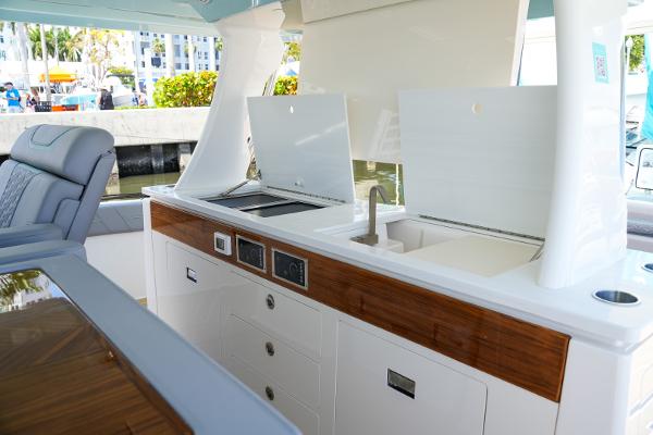 Slide: The Image of Outdoor kitchen area on the 2025 Regal 50 SAV yacht with sink and storage. - 12