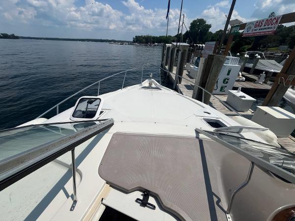 Slide: The Image of 1998 Regal 2760 boat docked by a serene lake under a partly cloudy sky. - 10