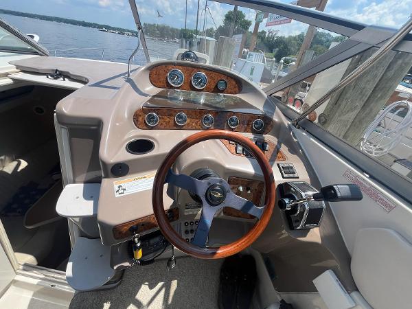 Slide: The Image of 1998 Regal 2760 boat dashboard with wood accents and steering wheel at marina. - 12