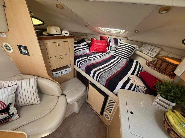 Slide: The Image of Cozy interior of 1998 Regal 2760 boat with striped bedding and compact seating area. - 16