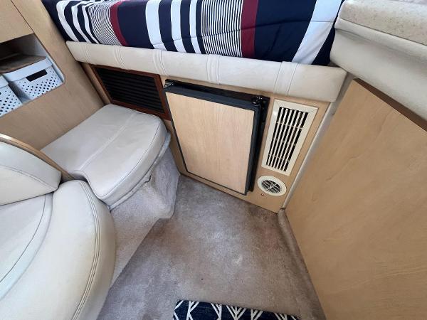 Slide: The Image of Interior of a 1998 Regal 2760 boat with seating and compact fridge. - 17