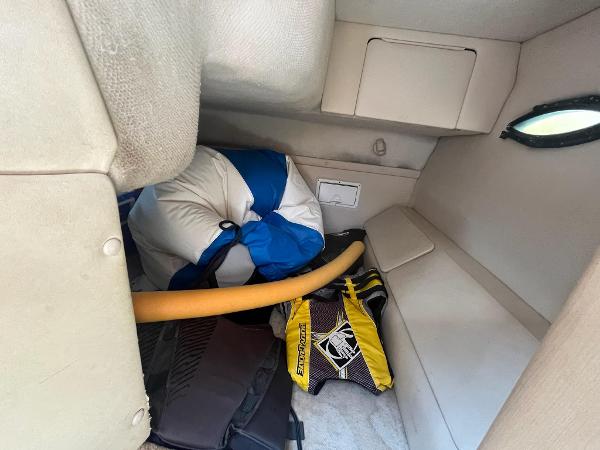 Slide: The Image of Interior storage area of a 1998 Regal 2760 boat with life jackets and equipment. - 22