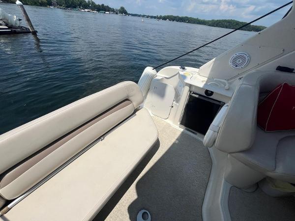 Slide: The Image of 1998 Regal 2760 boat interior with beige seating, docked on a serene lake. - 6