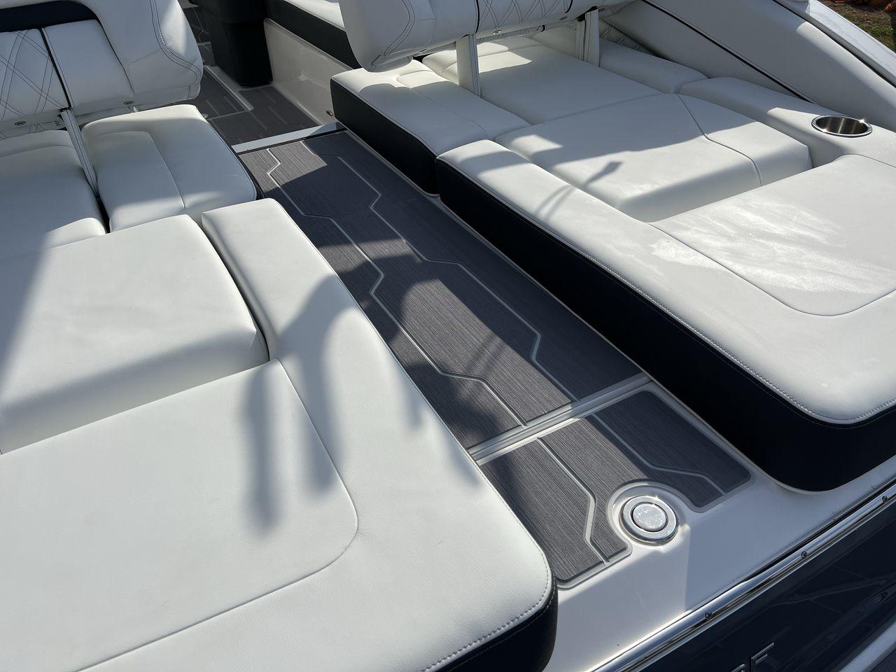 Slide: The Image of 2023 Regal LS6 Surf boat with luxurious white seating and modern deck design. - 11