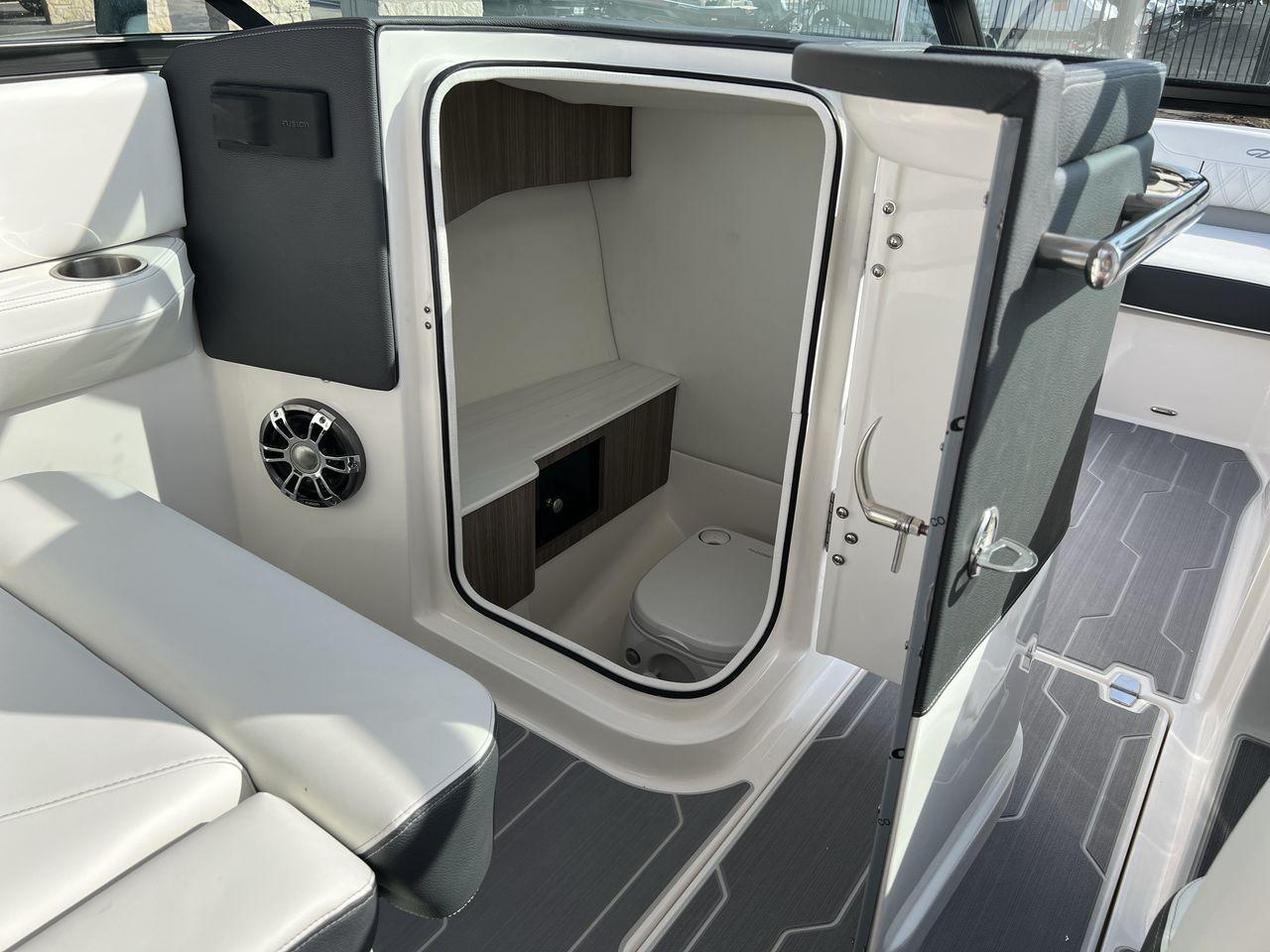 Slide: The Image of 2023 Regal LS6 Surf boat interior with open cabin door and seating. - 13