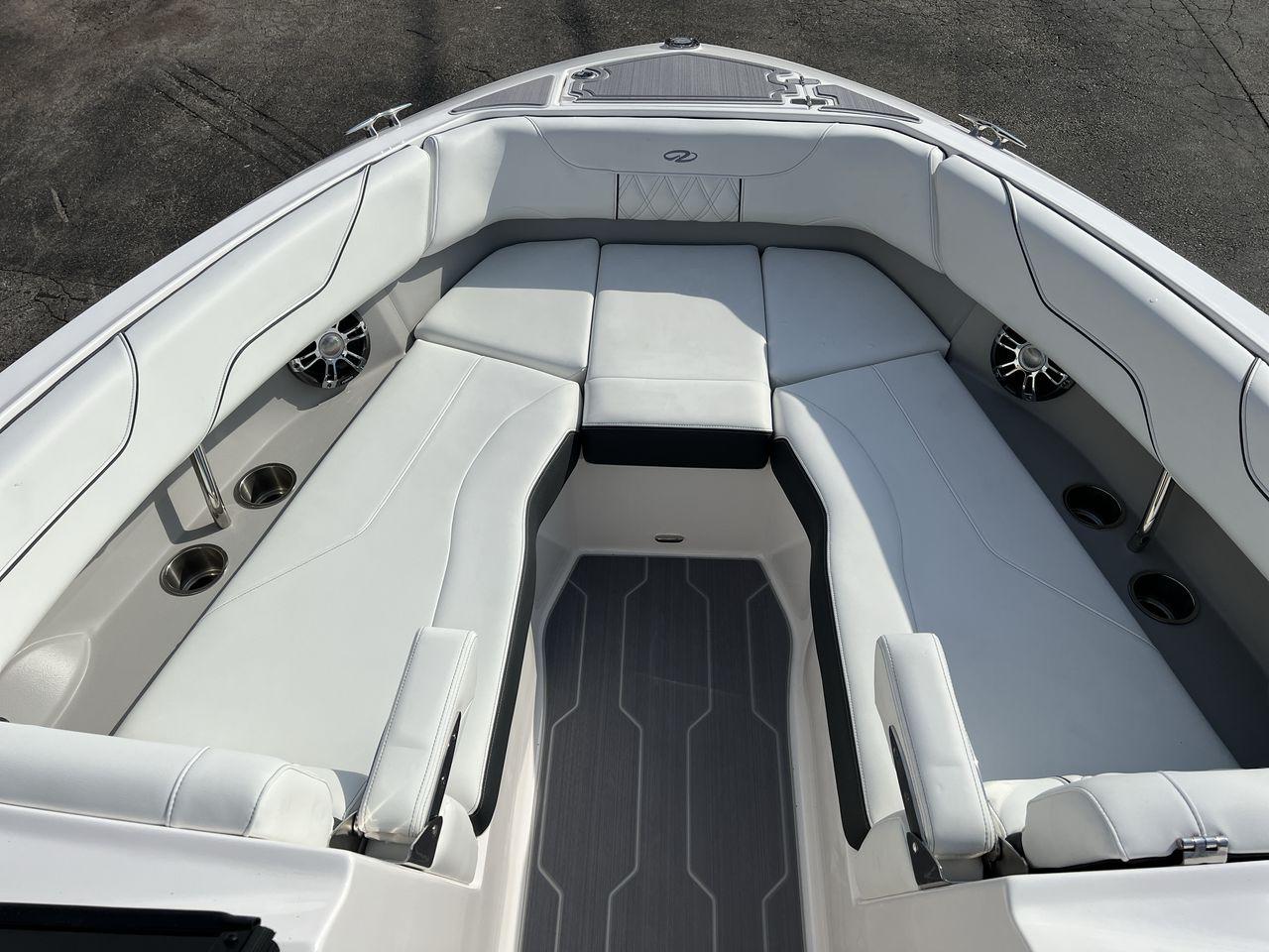 Slide: The Image of 2023 Regal LS6 Surf boat interior with white cushioned seating and cup holders. - 14