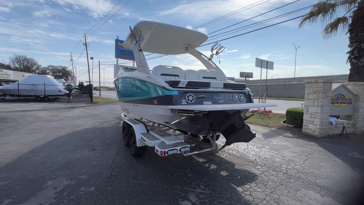 Slide: The Image of 2023 Regal LS6 Surf boat on a trailer in a dealership lot. - 23