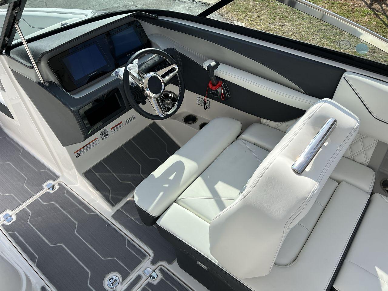 Slide: The Image of 2023 Regal LS6 Surf boat cockpit with modern steering wheel and dual screens. - 27