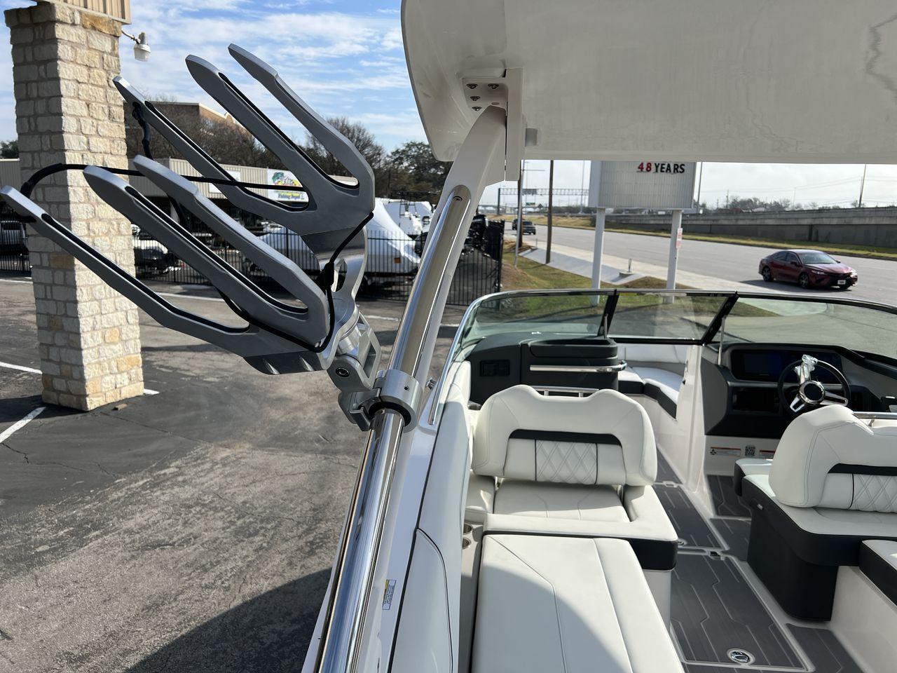 Slide: The Image of 2023 Regal LS6 Surf boat interior with wakeboard rack and seating. - 30