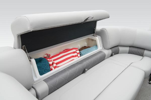 Slide: The Image of 2024 Regency 230 LE3 Sport boat storage compartment with towels and clothes. - 17