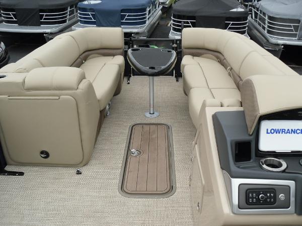 Slide: The Image of 2024 Regency 250 DL3 pontoon boat interior with beige seating and modern console. - 16