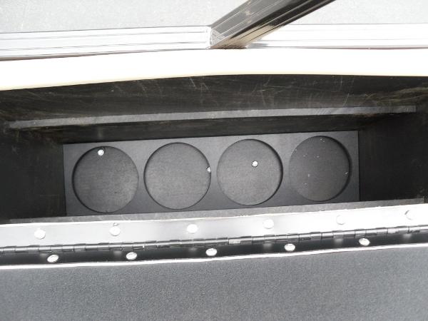 Slide: The Image of 2024 Regency 250 DL3 storage compartment with circular holders, open lid view. - 23