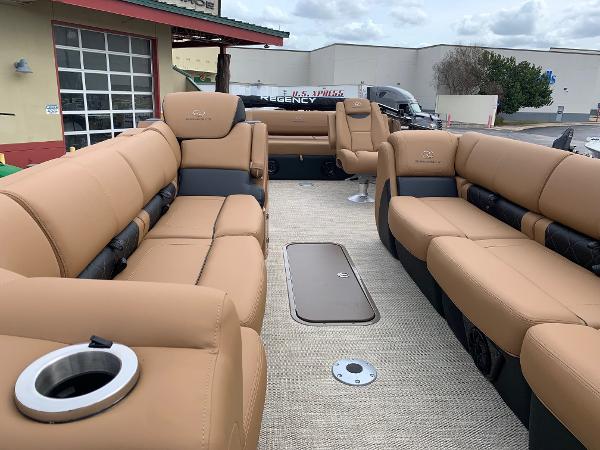 Slide: The Image of 2024 Regency 250 LE3 Sport boat interior with luxurious tan seating and cup holders. - 3
