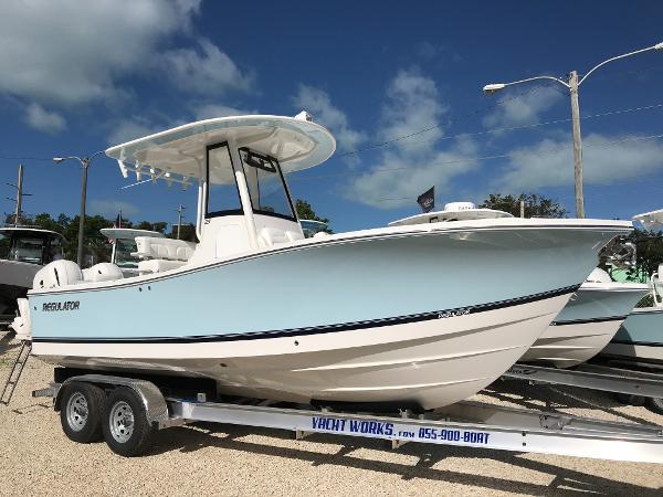 Slide: The Image of 2023 Regulator 23 boat on trailer under clear blue sky. - 0