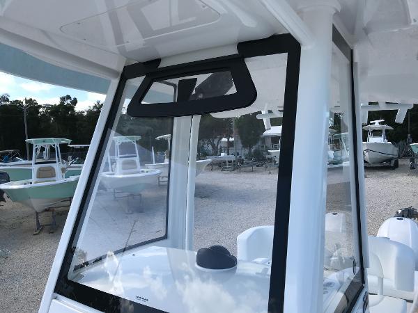 Slide: The Image of 2023 Regulator 23 boat with sleek windshield design in a marina setting. - 18