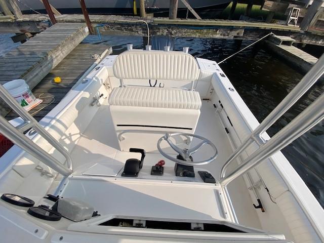 Slide: The Image of 2005 Regulator 23 Center Console boat interior at dock, featuring steering wheel and seating. - 11