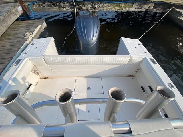 Slide: The Image of 2005 Regulator 23 Center Console boat with rod holders and outboard motor at dock. - 13