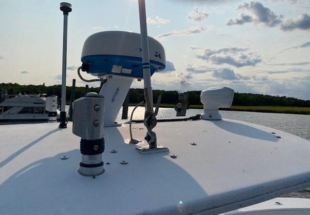 Slide: The Image of 2005 Regulator 23 Center Console boat with radar equipment on deck, scenic water backdrop. - 14