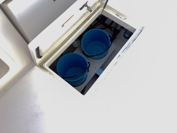 Slide: The Image of Storage compartment with blue buckets on 2025 Regulator 23 Center Console boat. - 10