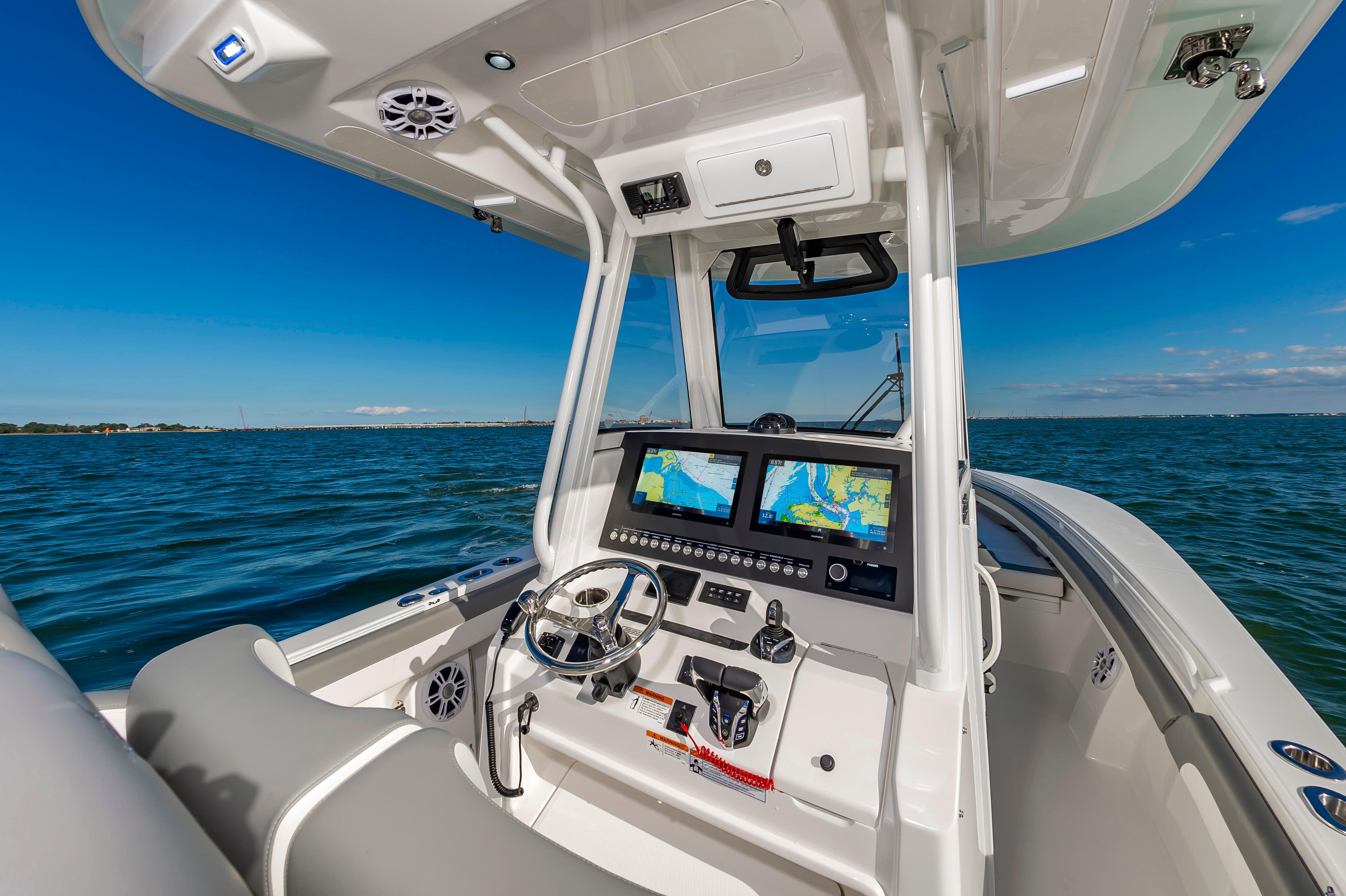 Slide: The Image of 2024 Regulator 28 boat cockpit with dual navigation screens and ocean view. - 10