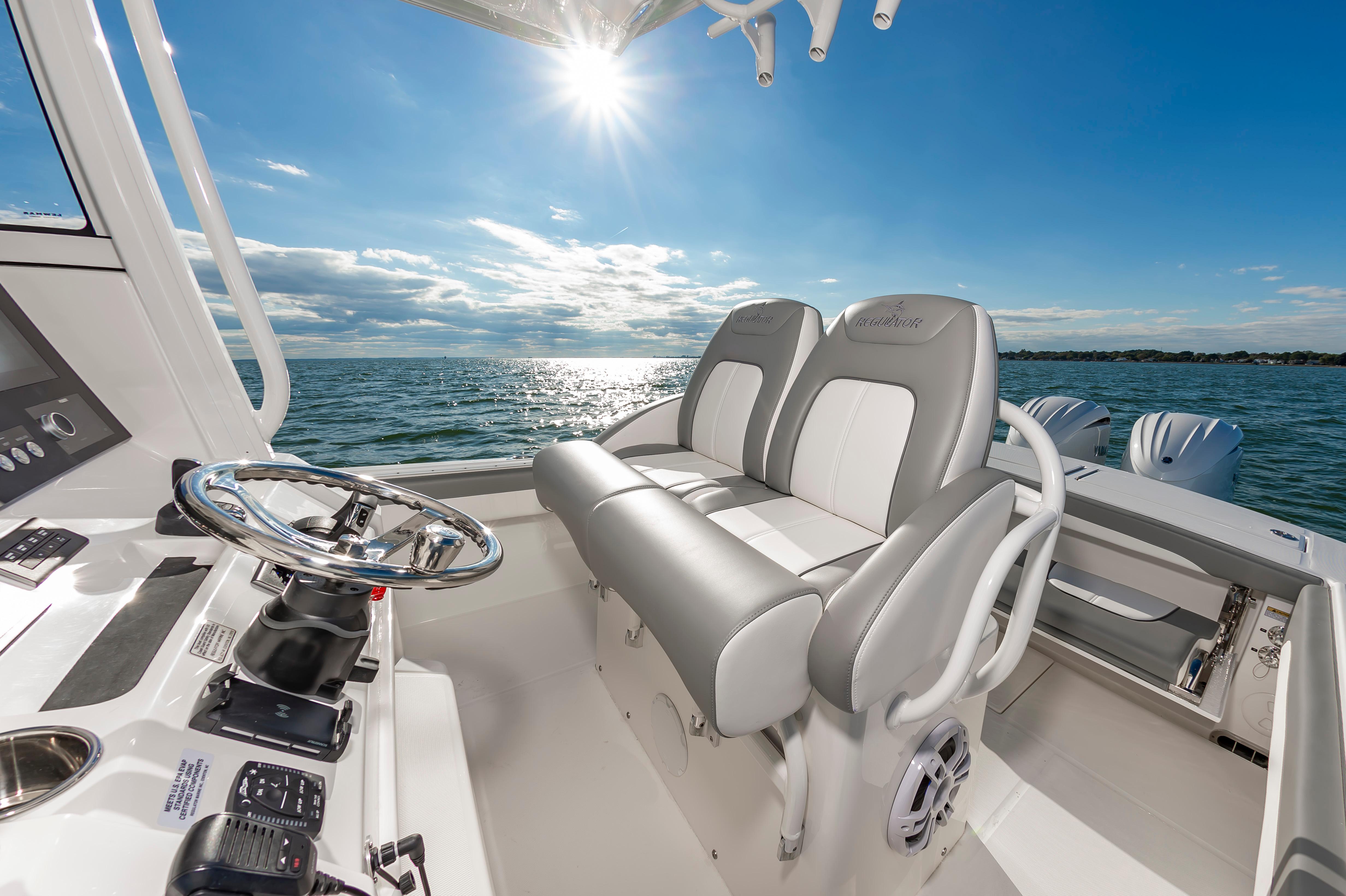Slide: The Image of 2024 Regulator 28 boat interior with dual seats and steering wheel on open water. - 11
