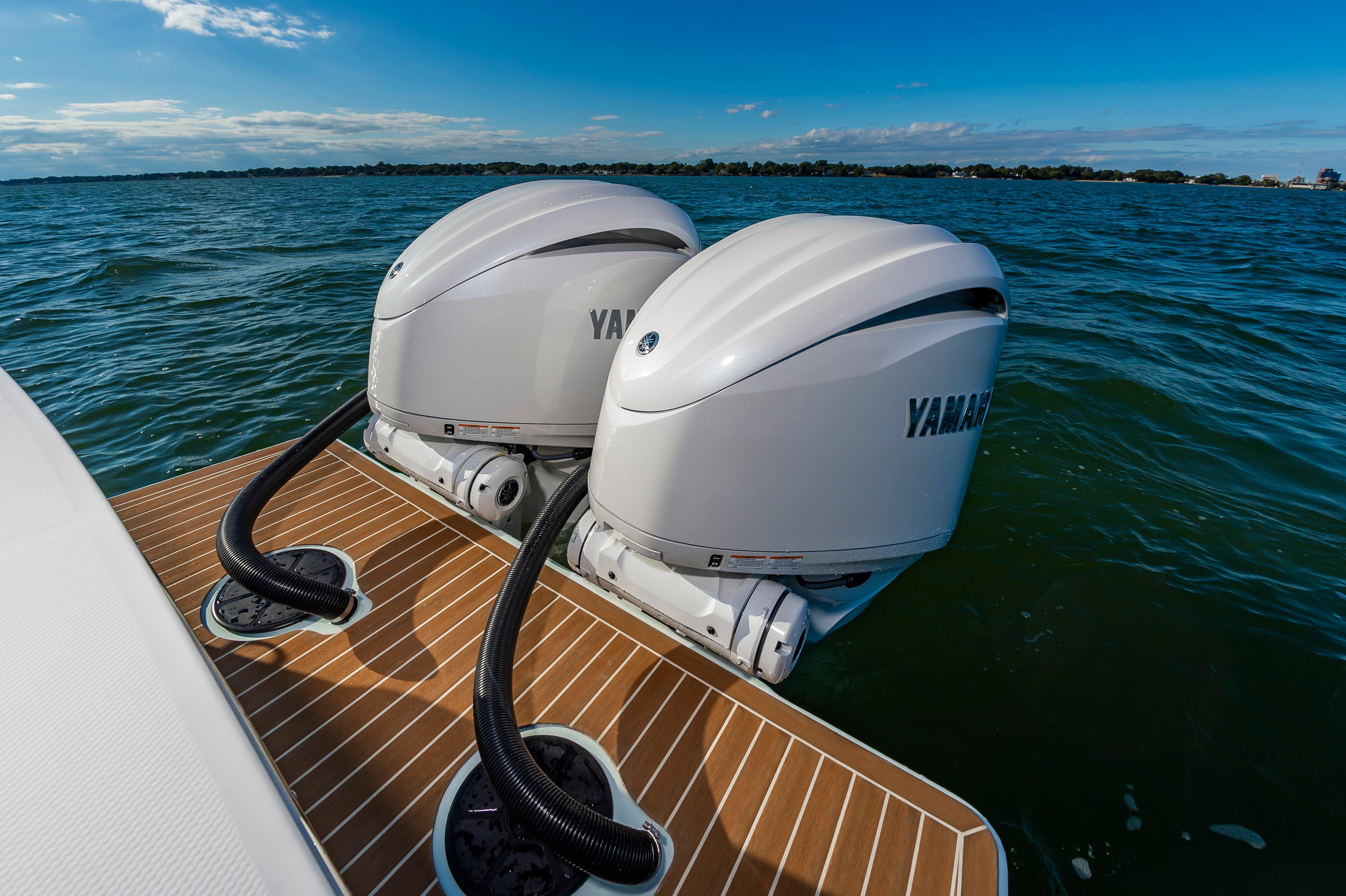Slide: The Image of Twin Yamaha outboard engines on a 2024 Regulator 28 boat, docked on water. - 19