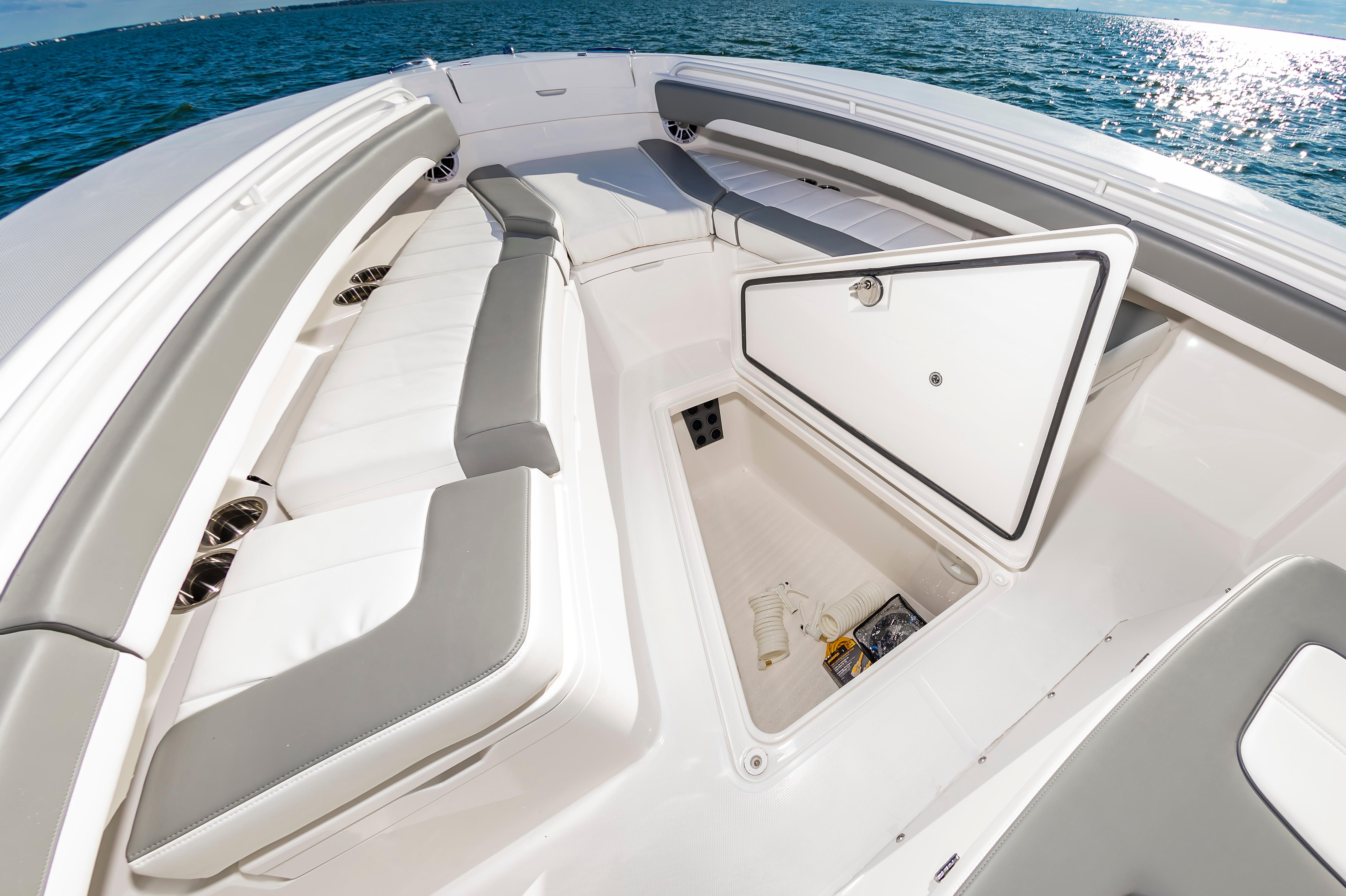 Slide: The Image of 2024 Regulator 28 boat with open storage compartment and cushioned seating. - 23