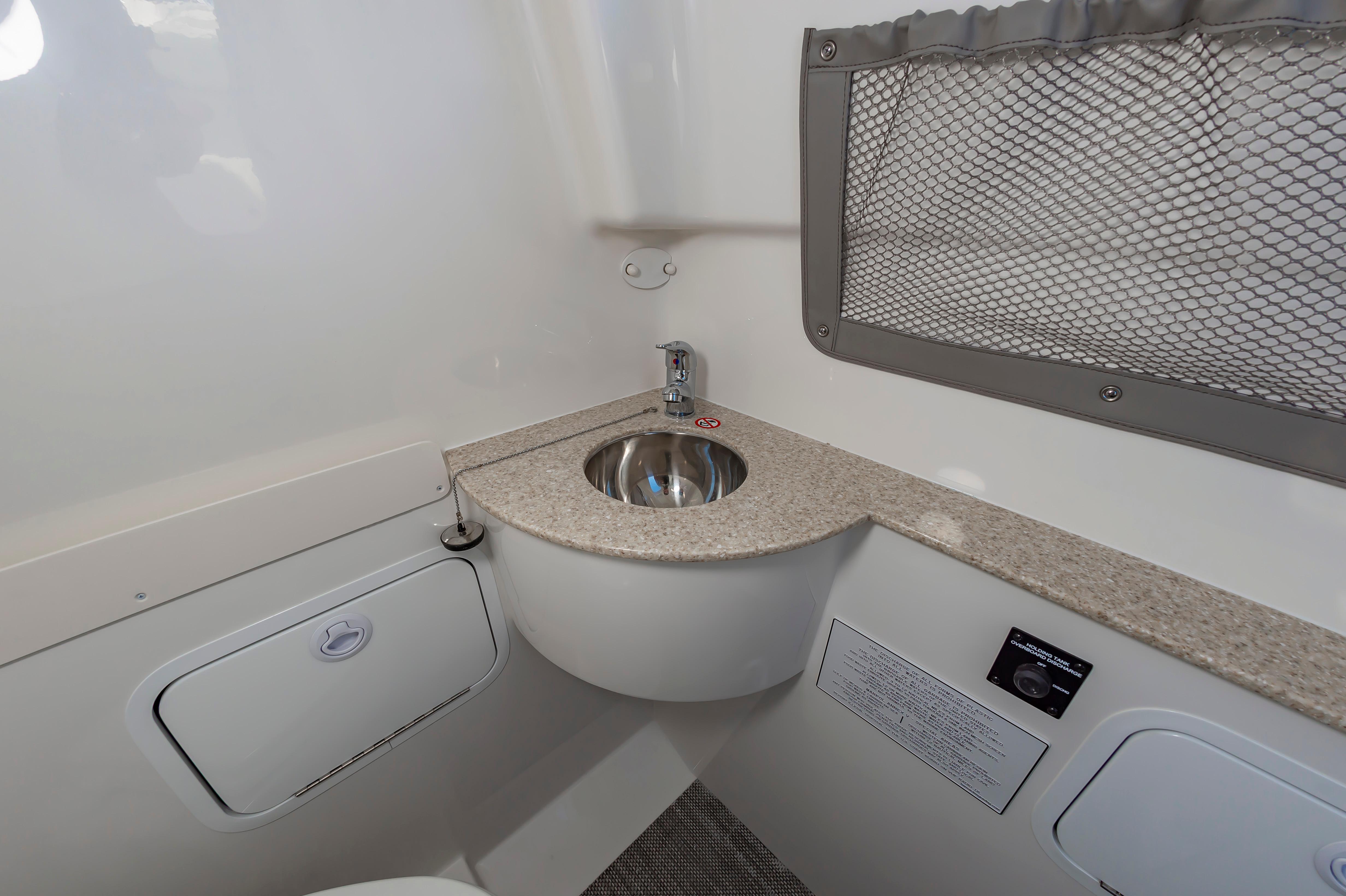 Slide: The Image of 2024 Regulator 28 boat interior sink and countertop with storage compartments. - 30