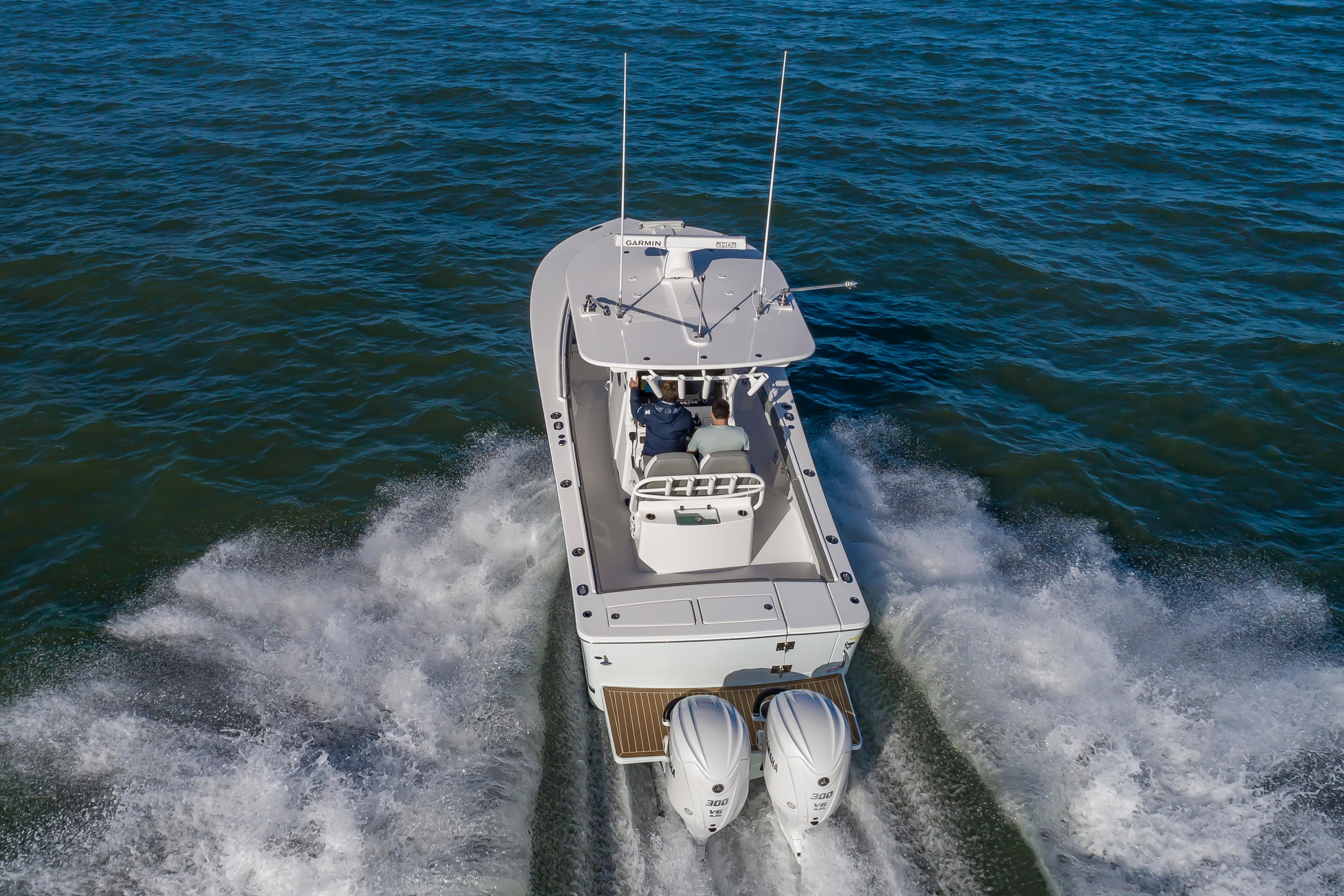 Slide: The Image of 2024 Regulator 28 boat cruising on open water with twin Yamaha engines. - 7