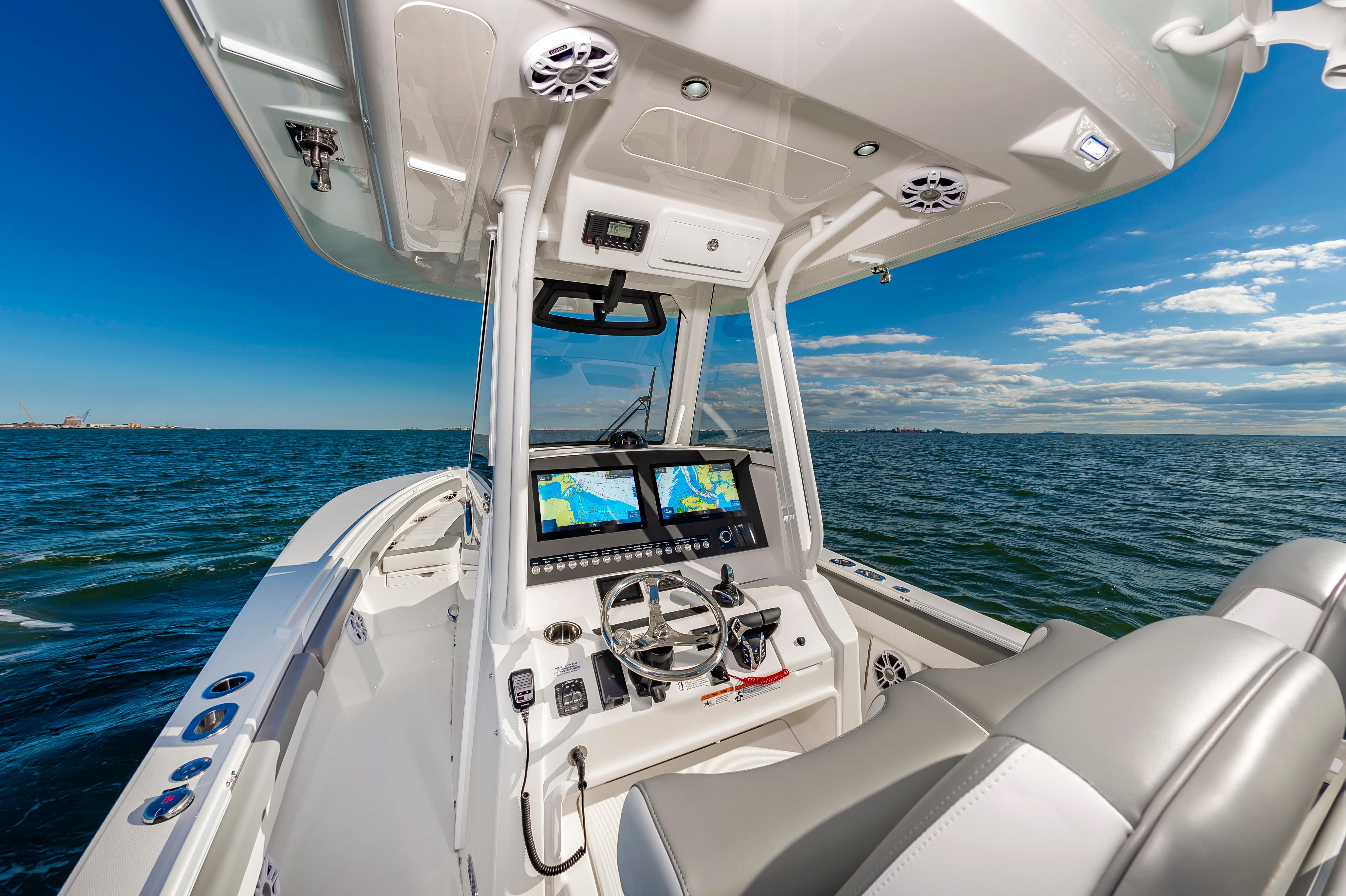 Slide: The Image of 2024 Regulator 28 boat dashboard with dual navigation screens on open water. - 8