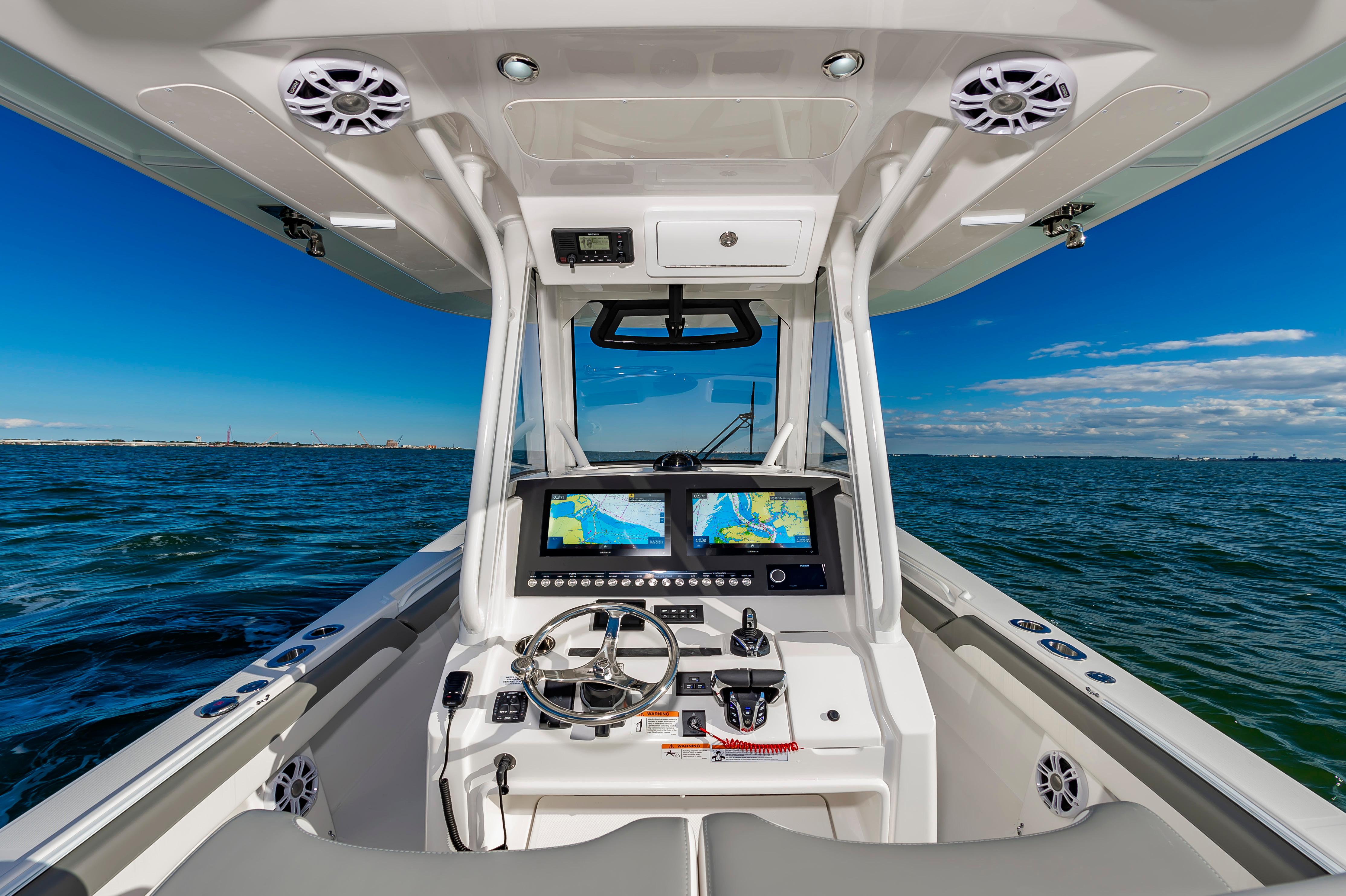 Slide: The Image of 2024 Regulator 28 boat dashboard with dual navigation screens on open water. - 9