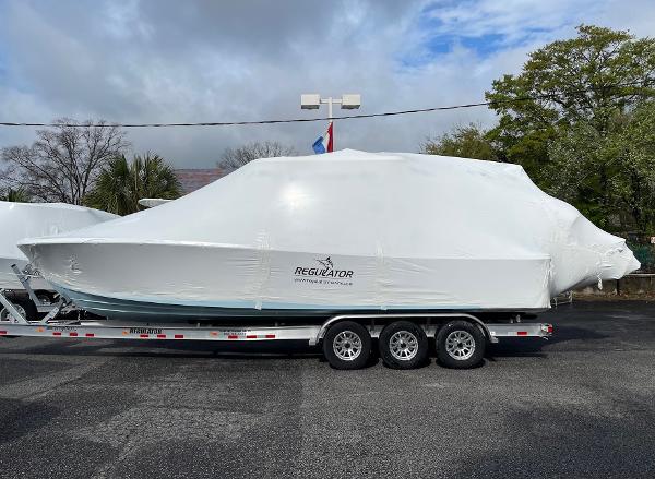 Slide: The Image of 2024 Regulator 30XO boat covered in white shrink wrap on a trailer. - 18
