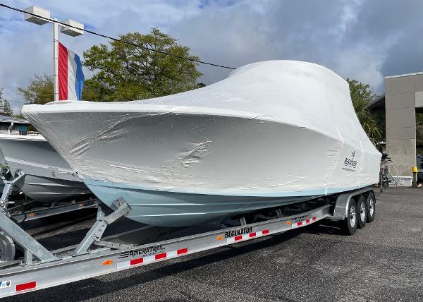 Slide: The Image of 2024 Regulator 30XO boat covered on a trailer in a parking lot. - 19