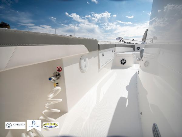 Slide: The Image of 2024 Regulator 30XO boat interior with white seating and deck, under a blue sky. - 34