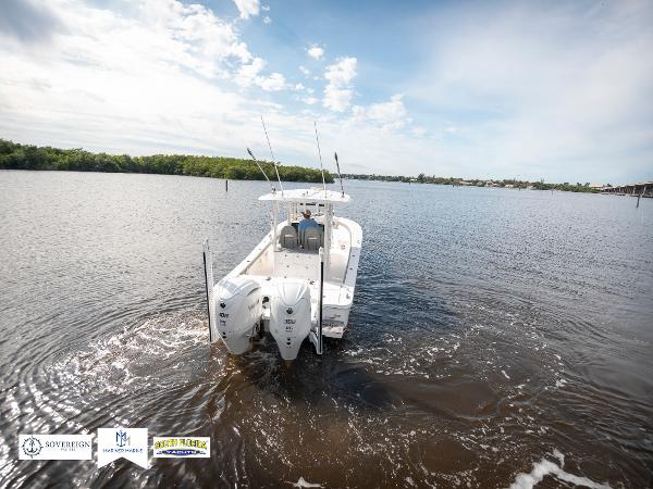 Slide: The Image of 2024 Regulator 30XO boat cruising on a calm river under a clear sky. - 4