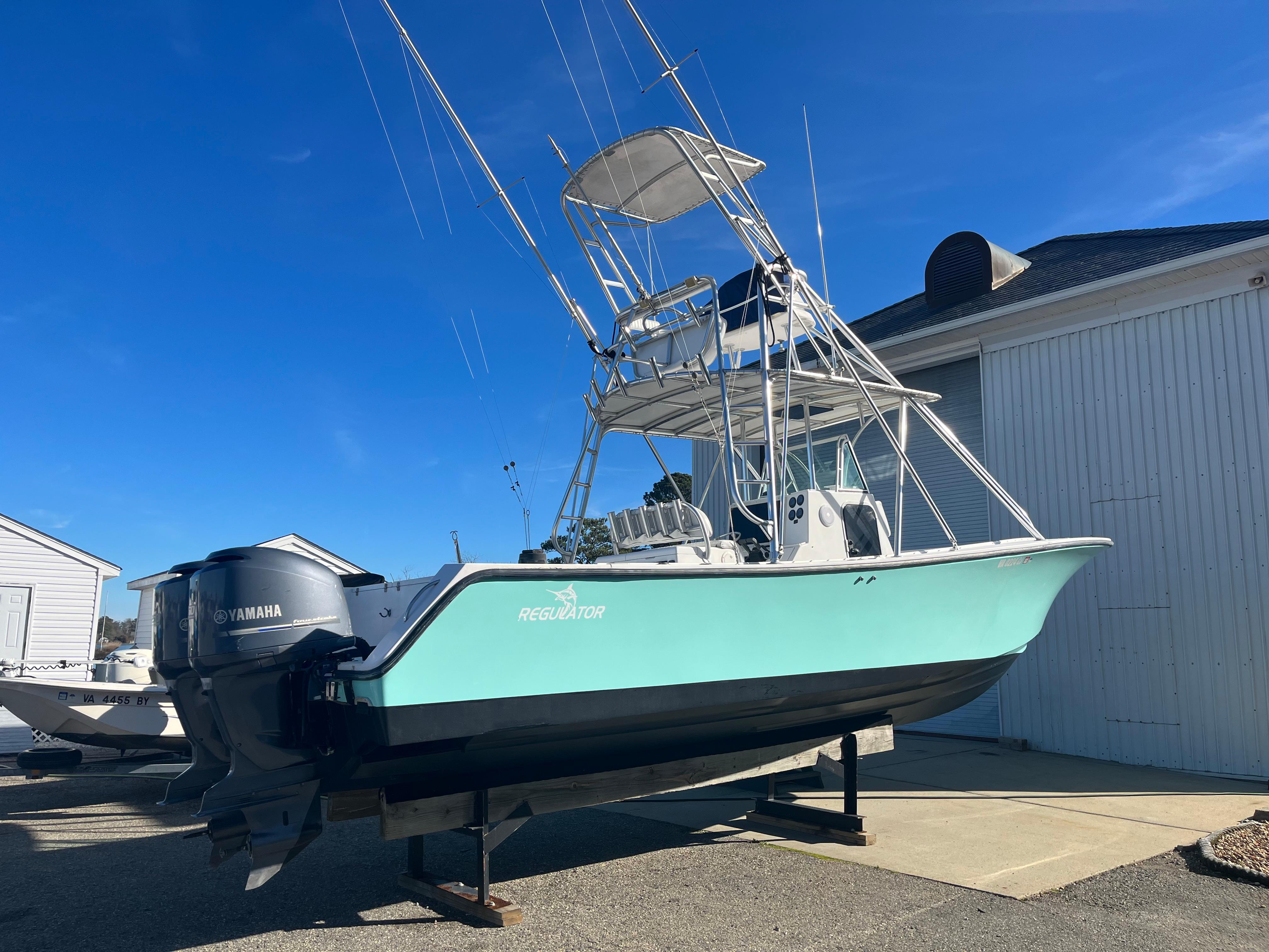 Slide: The Image of 2000 Regulator 32 Center Console boat with Yamaha engines, displayed outdoors. - 1