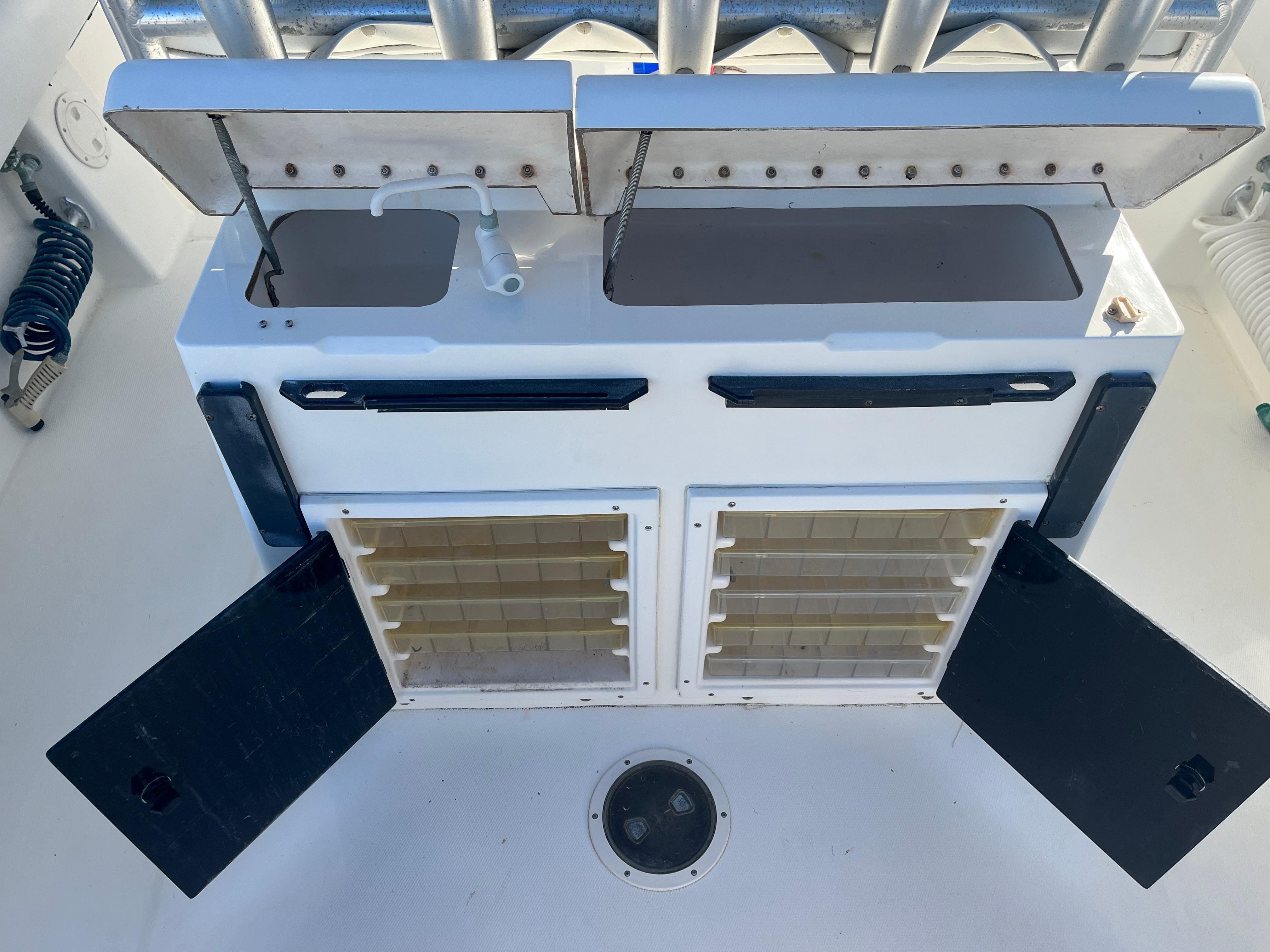 Slide: The Image of 2000 Regulator 32 Center Console fishing station with storage compartments and rod holders. - 10
