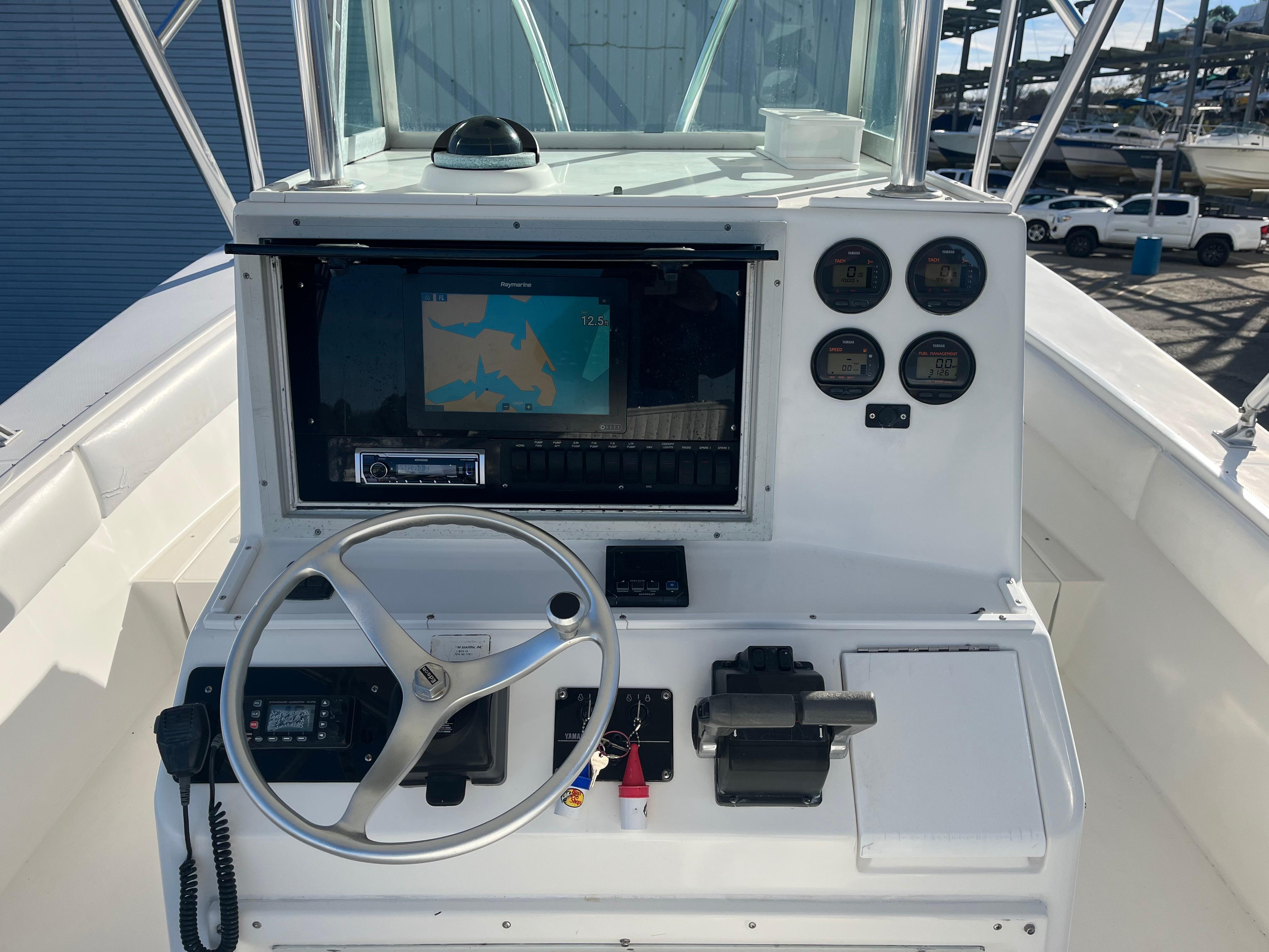 Slide: The Image of Center console of 2000 Regulator 32 boat with steering wheel and navigation display. - 11