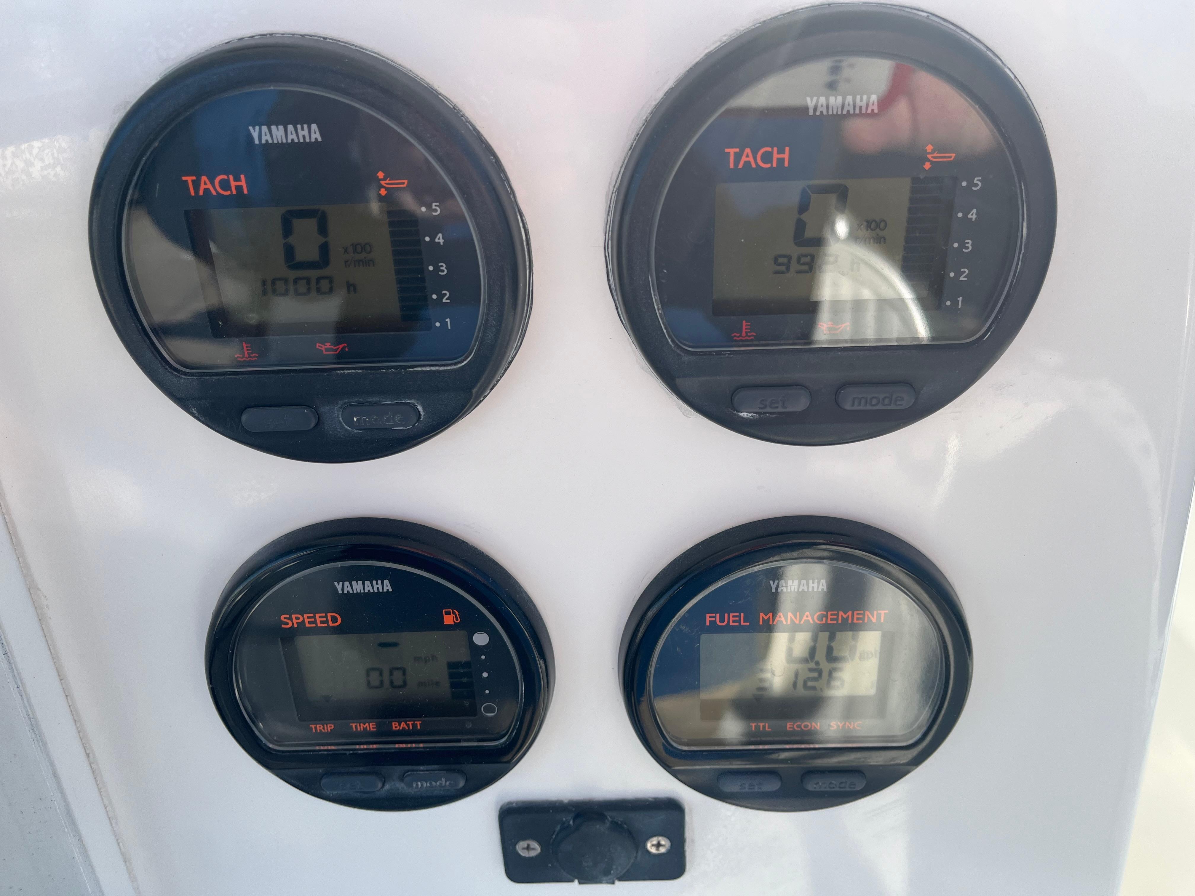 Slide: The Image of Yamaha gauges on a 2000 Regulator 32 Center Console boat dashboard. - 12