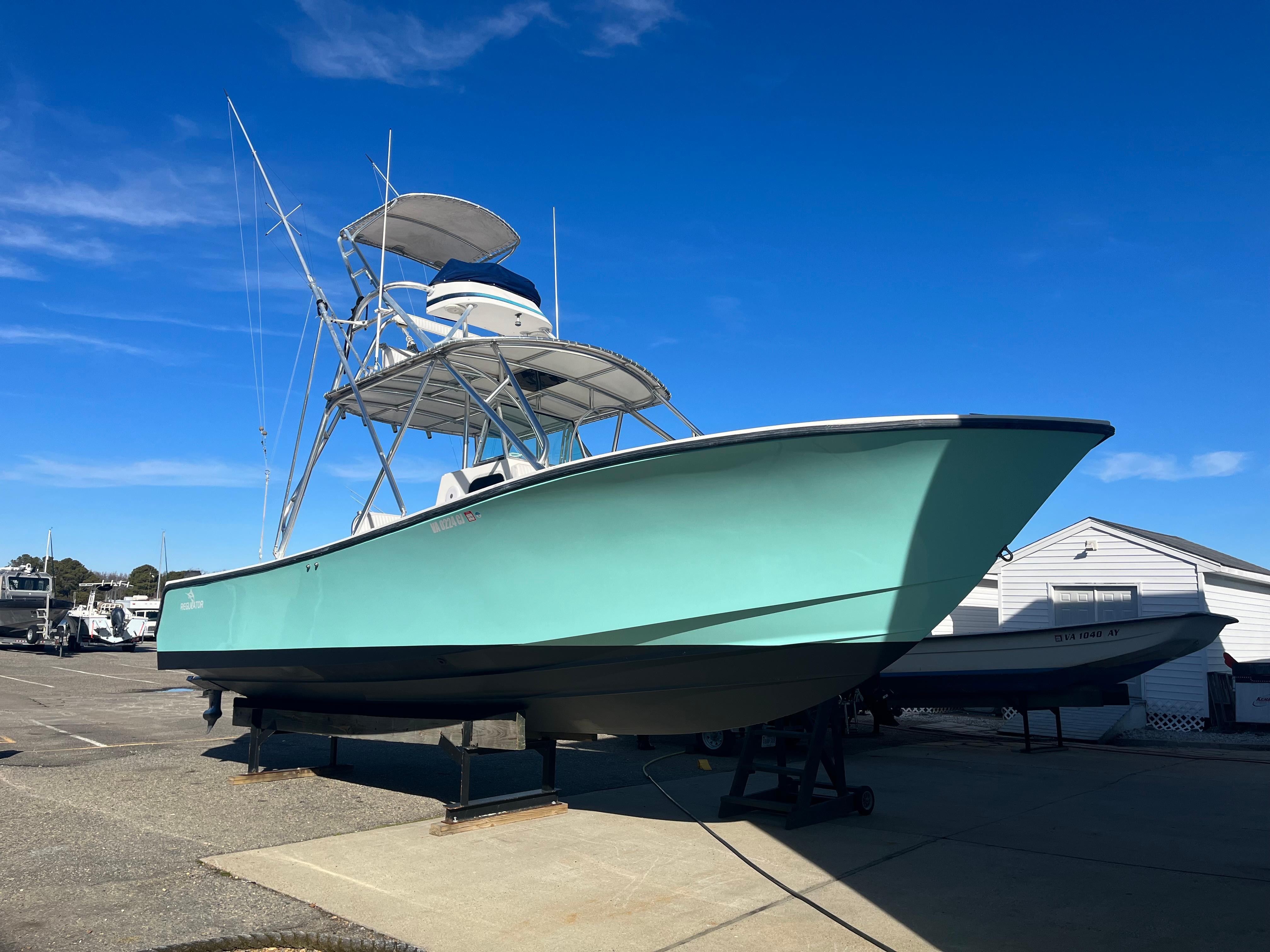 Slide: The Image of 2000 Regulator 32 Center Console boat on display under clear blue sky. - 2