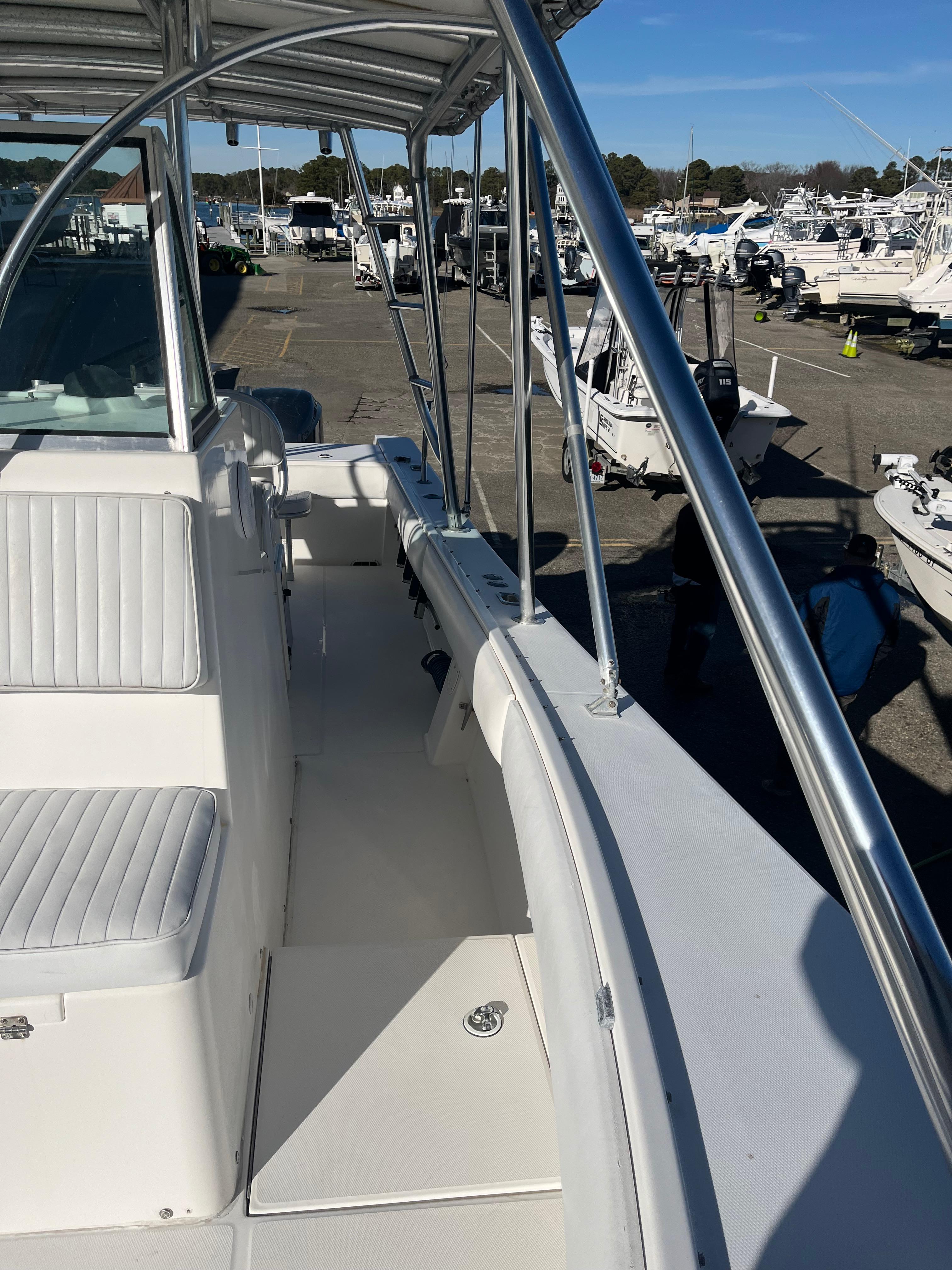 Slide: The Image of 2000 Regulator 32 Center Console boat with white seating, docked at a marina. - 22