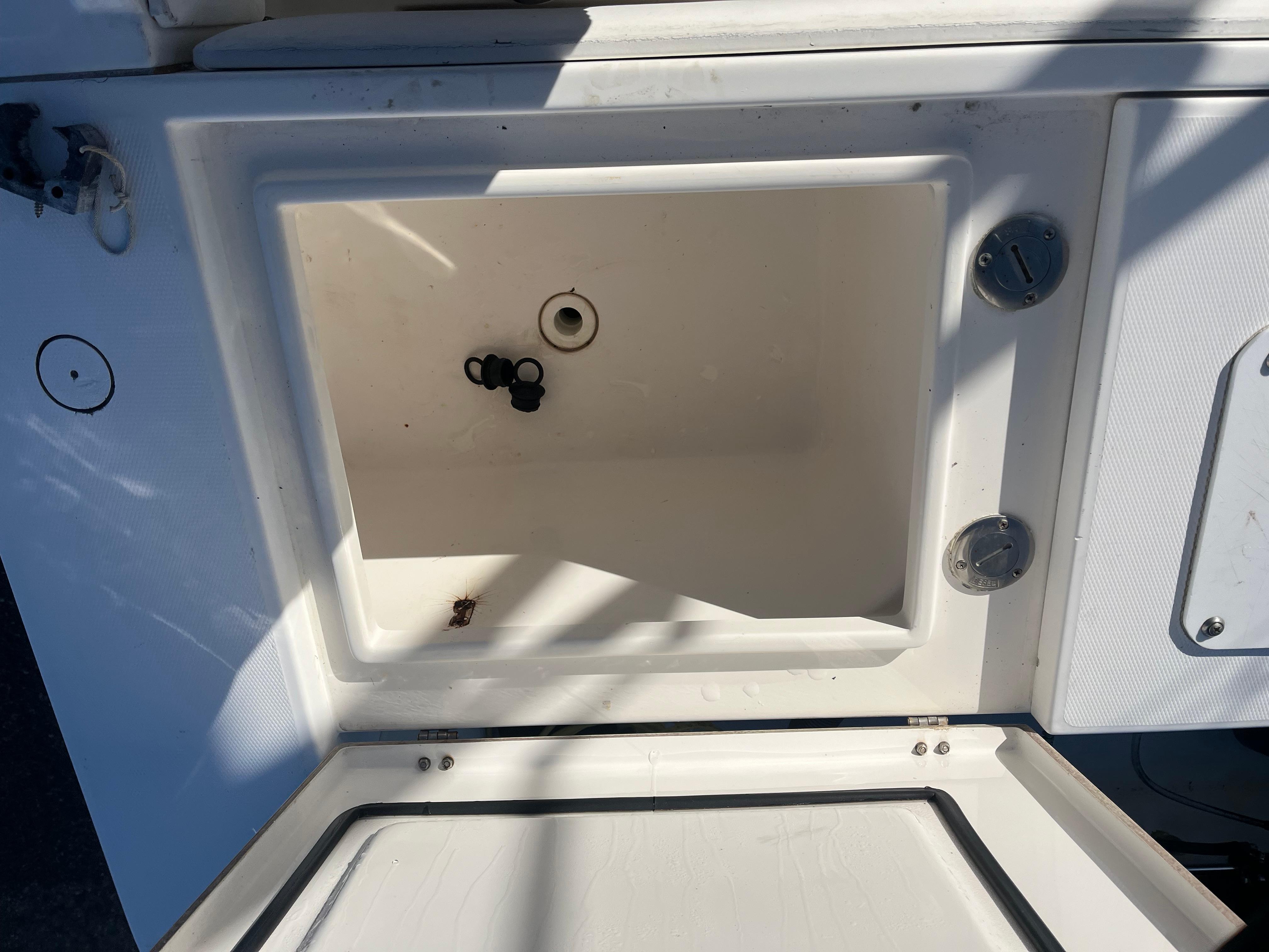 Slide: The Image of Open storage compartment on a 2000 Regulator 32 Center Console boat. - 24