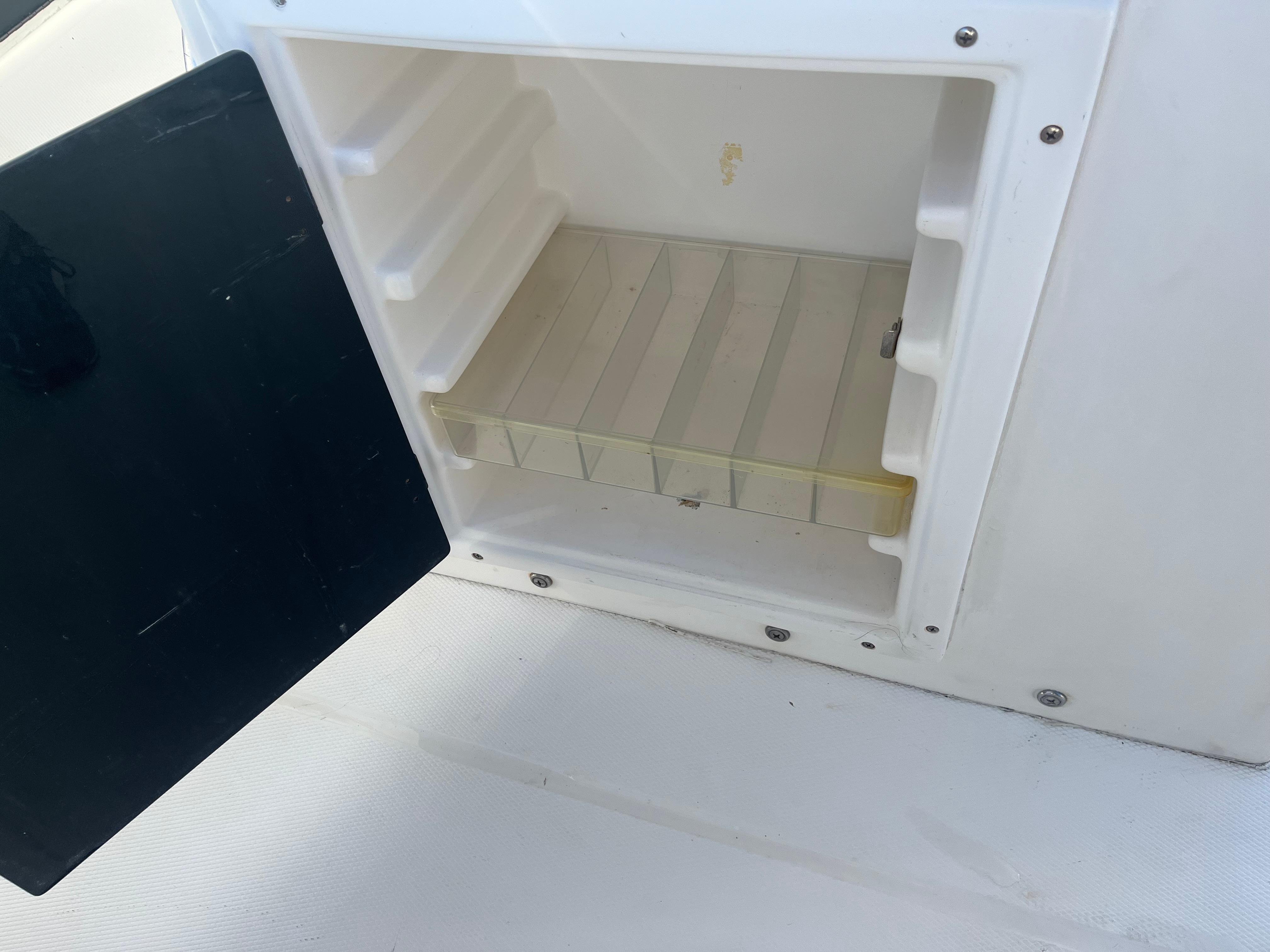 Slide: The Image of Open storage compartment on a 2000 Regulator 32 Center Console boat. - 25