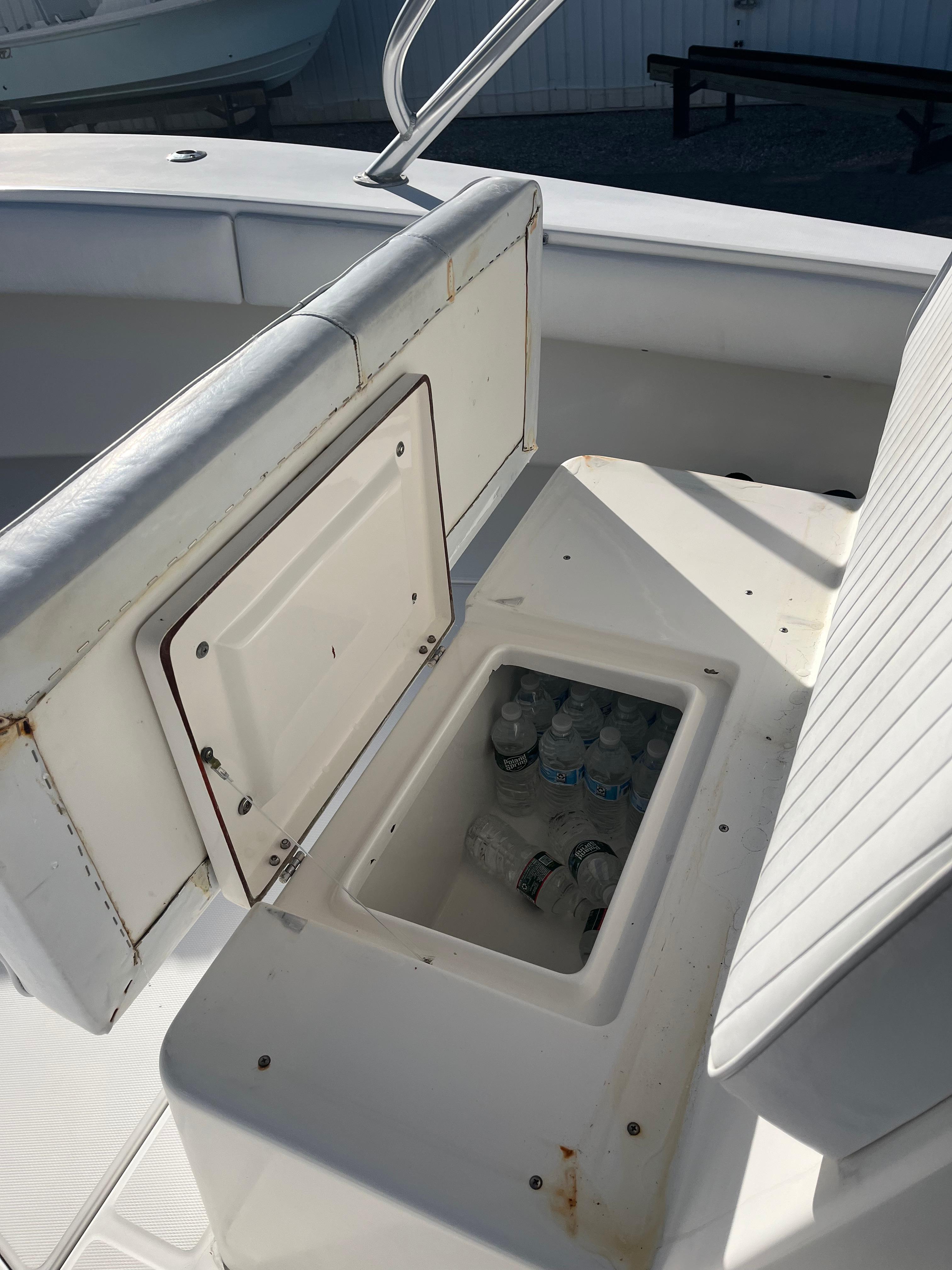 Slide: The Image of Open storage compartment on 2000 Regulator 32 Center Console boat with water bottles inside. - 28