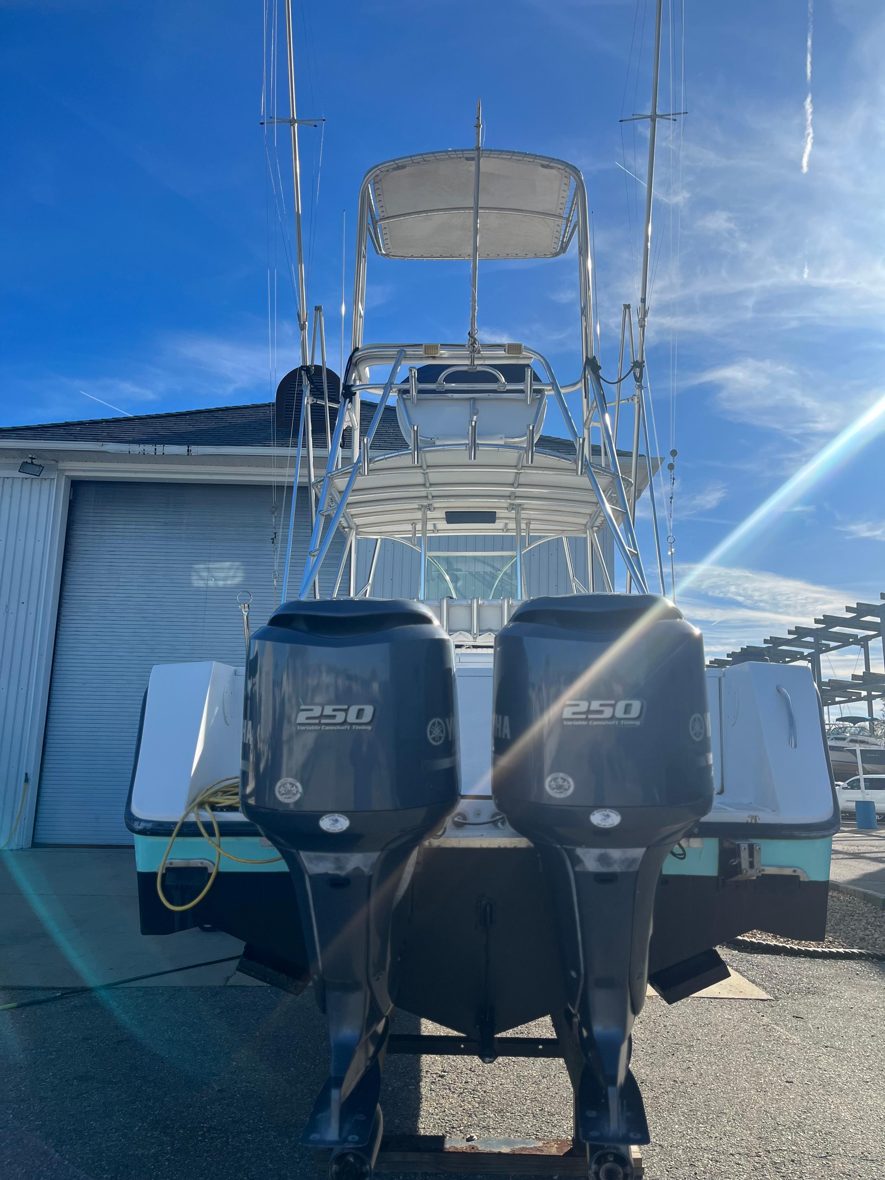 Slide: The Image of 2000 Regulator 32 Center Console boat with dual 250 horsepower engines, docked under clear blue sky. - 3