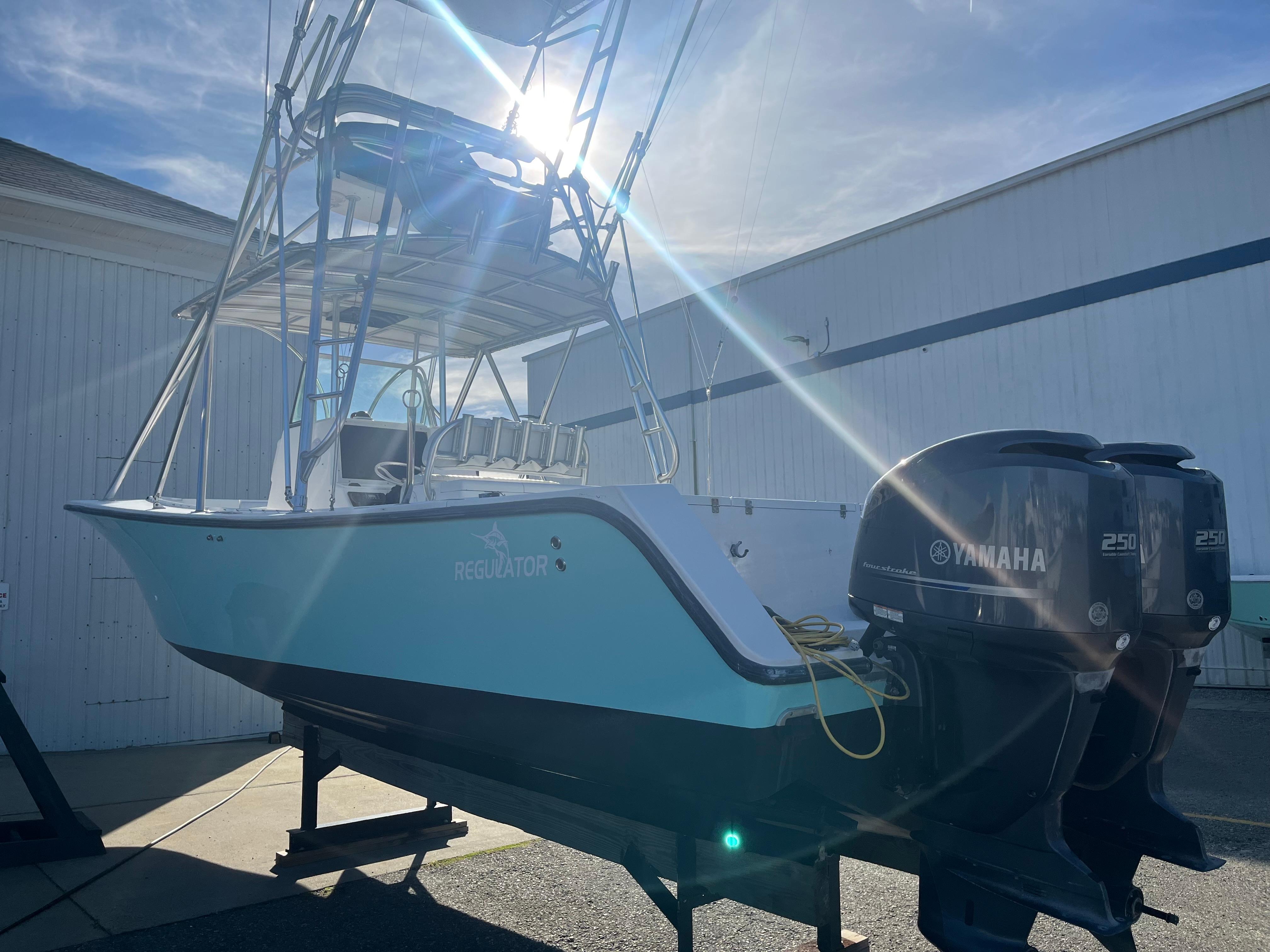 Slide: The Image of 2000 Regulator 32 Center Console boat with dual Yamaha 250 engines, docked under sunlight. - 4