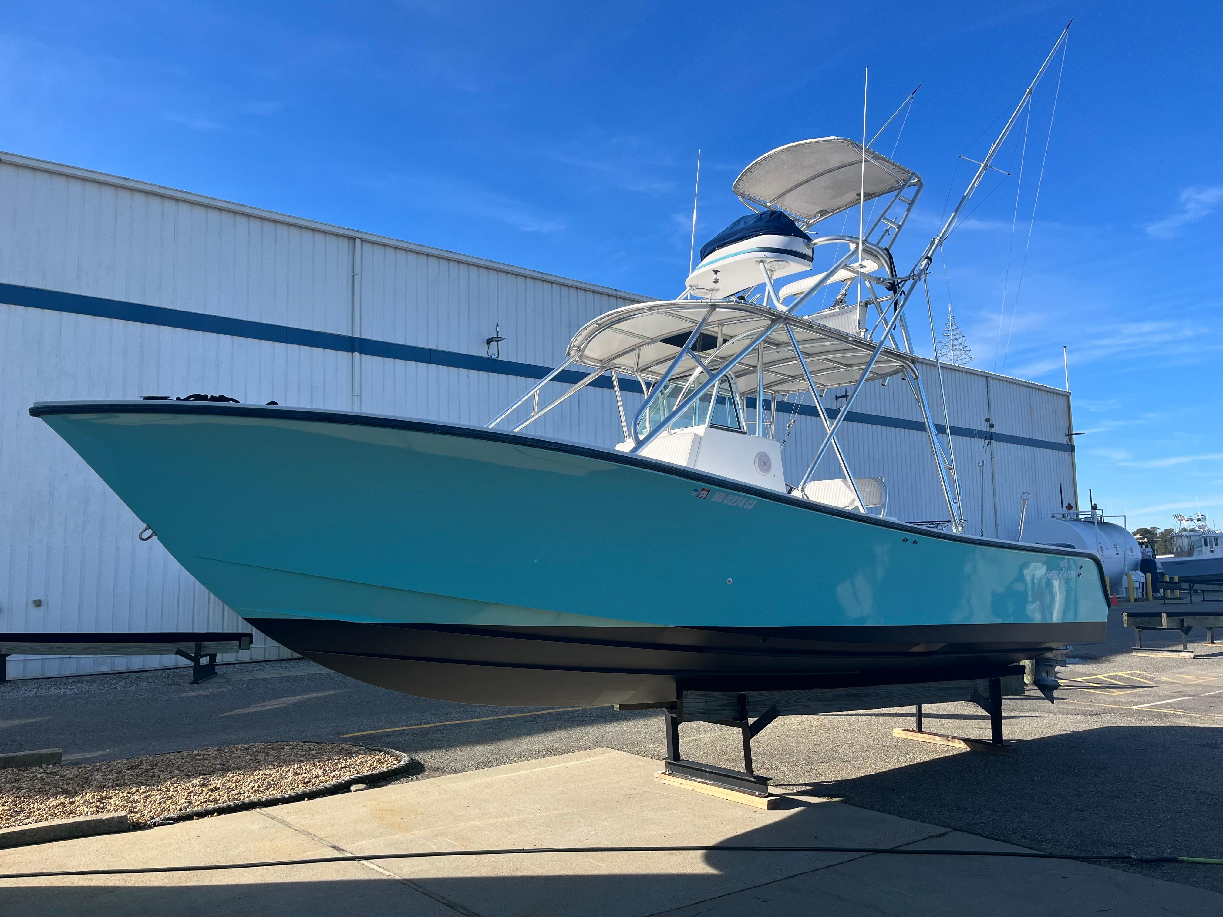 Slide: The Image of 2000 Regulator 32 Center Console boat on display, featuring a sleek blue hull. - 5