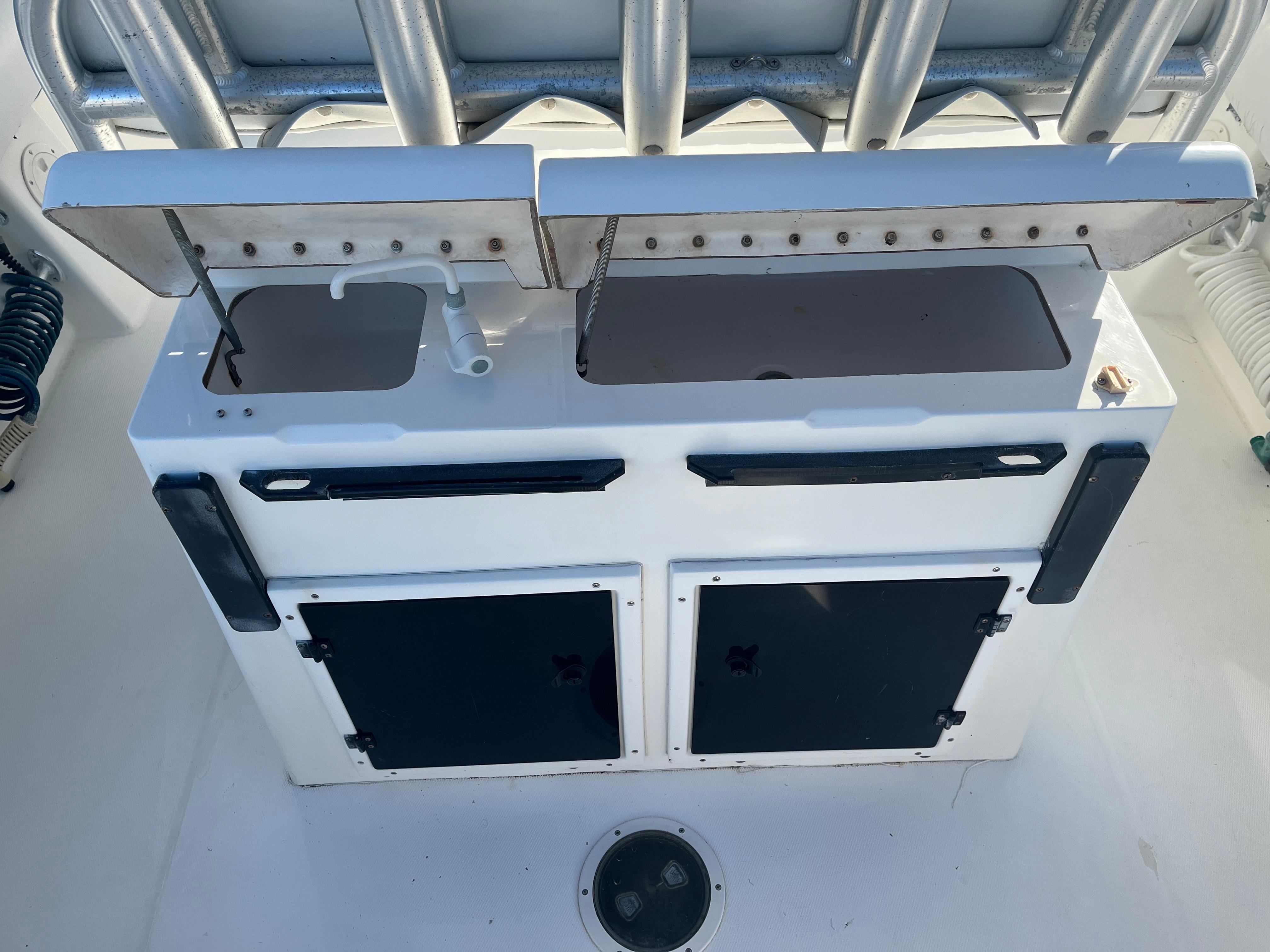 Slide: The Image of 2000 Regulator 32 Center Console fishing station with storage compartments and rod holders. - 9