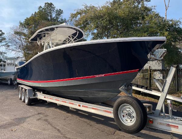 Slide: The Image of 2016 Regulator 34SS boat on trailer, dark blue hull, parked outdoors. - 14