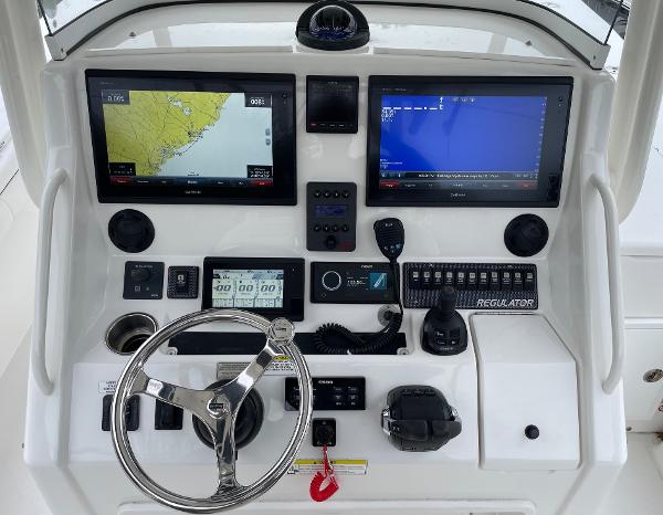 Slide: The Image of Control panel of a 2016 Regulator 34SS boat with navigation screens and steering wheel. - 24